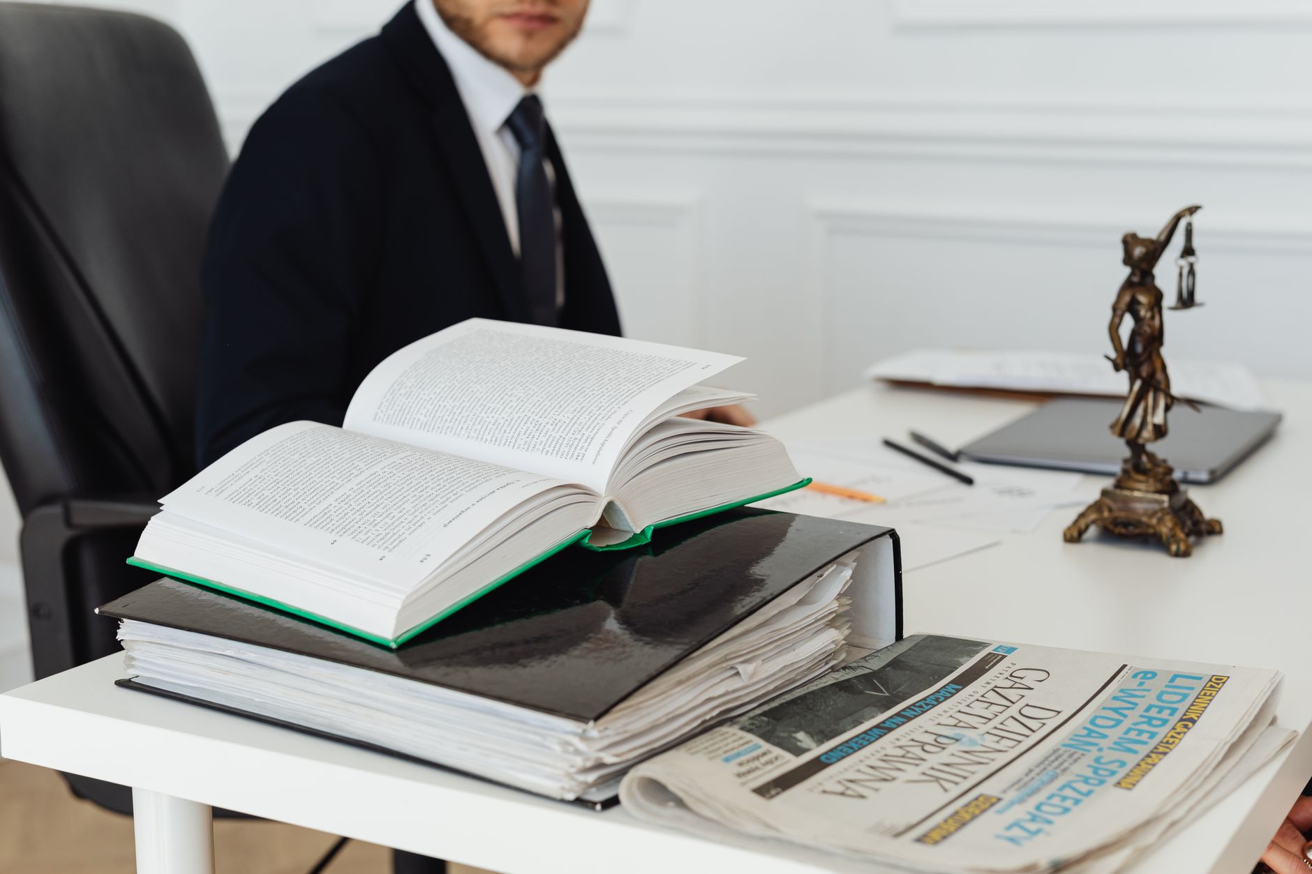 labour renters rights tribunal backlog: A lawyer sitting at a desk with legal books, documents, and a newspaper, embodying pr